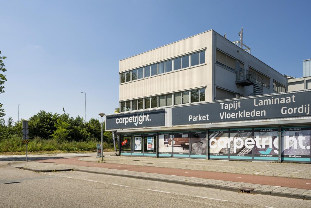 Vooraanzicht van het Carpetright-winkelpand aan de Anthony Fokkerweg met reclame voor vloerbedekking en gordijnen.